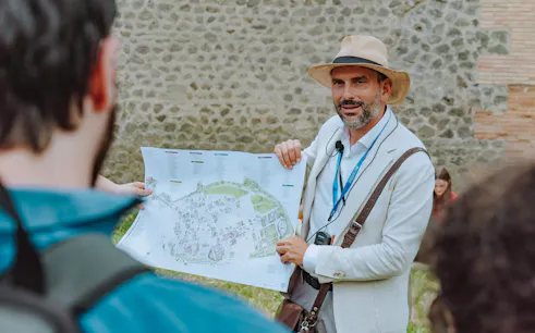 Tour guide in Pompeii holding a map and briefing tourists.