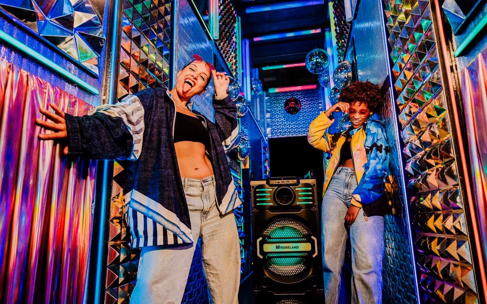 Visitors enjoying vibrant room at Upside Down Amsterdam with colorful lights and decor.