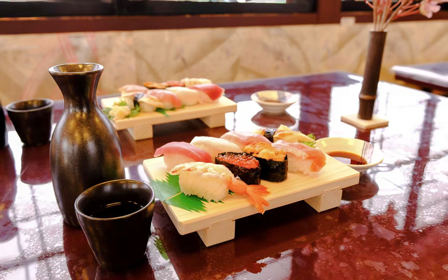 Sushi platter with sake on a table, Tokyo Sumo Performance dining experience.