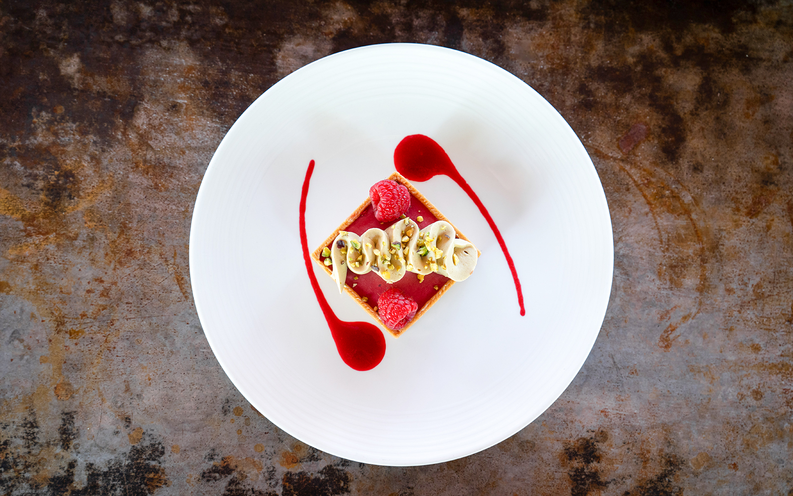 Dessert with raspberries and cream on a white plate at Bateaux Mouches, Paris.