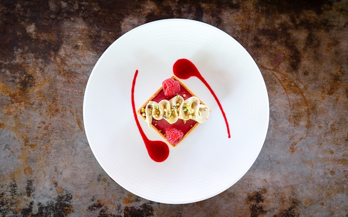Dessert with raspberries and cream on a white plate at Bateaux Mouches, Paris.