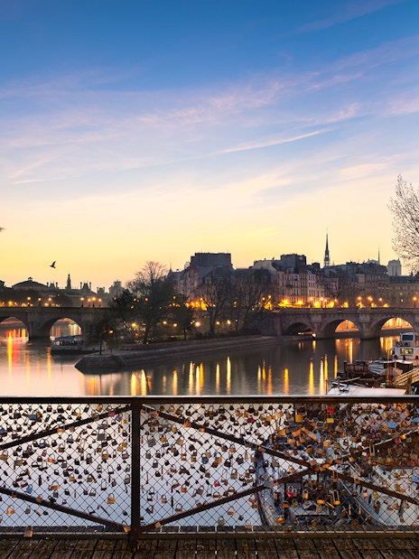 Pont des Arts with evening lights and love locks in Paris.