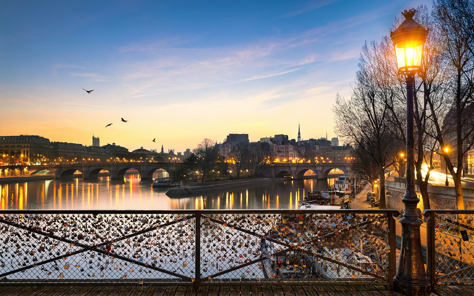 Pont des Arts with evening lights and love locks in Paris.