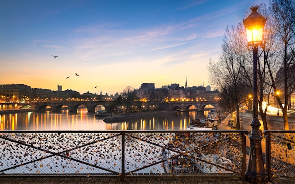 Pont des Arts with evening lights and love locks in Paris.