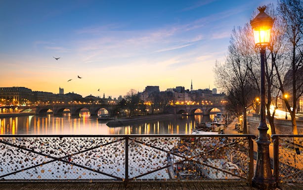 Pont des Arts with evening lights and love locks in Paris.