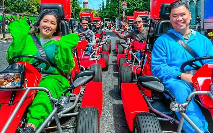 People in costumes driving go-karts on a street in Shibuya, Tokyo.