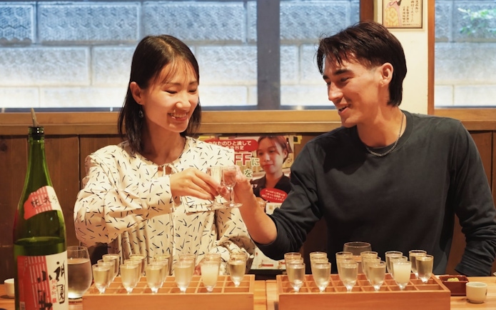People enjoying sake tasting at a Kyoto brewery during a walking tour.
