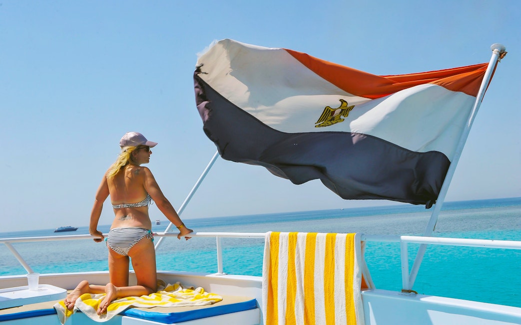 Woman on cruise deck with Egyptian flag, Red Sea, Hurghada.