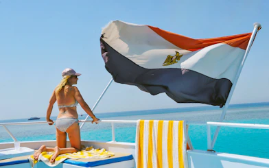 Woman on cruise deck with Egyptian flag, Red Sea, Hurghada.