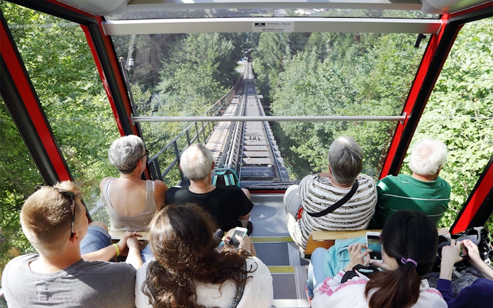 Passengers riding a funicular through lush greenery with Jungfrau Travel Pass.