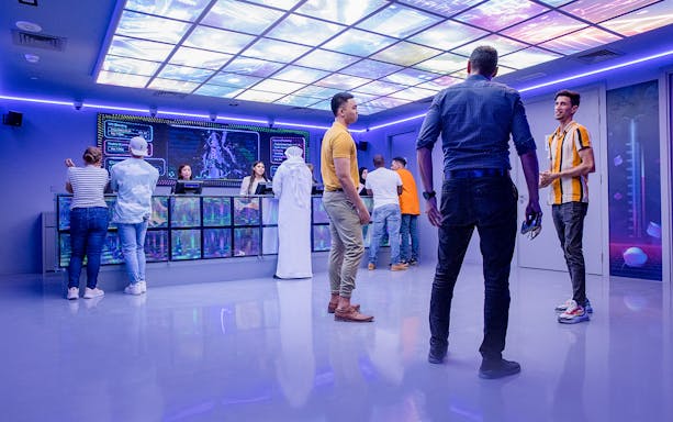 Visitors at Pixoul Gaming entrance in Abu Dhabi, interacting with staff at the reception desk.