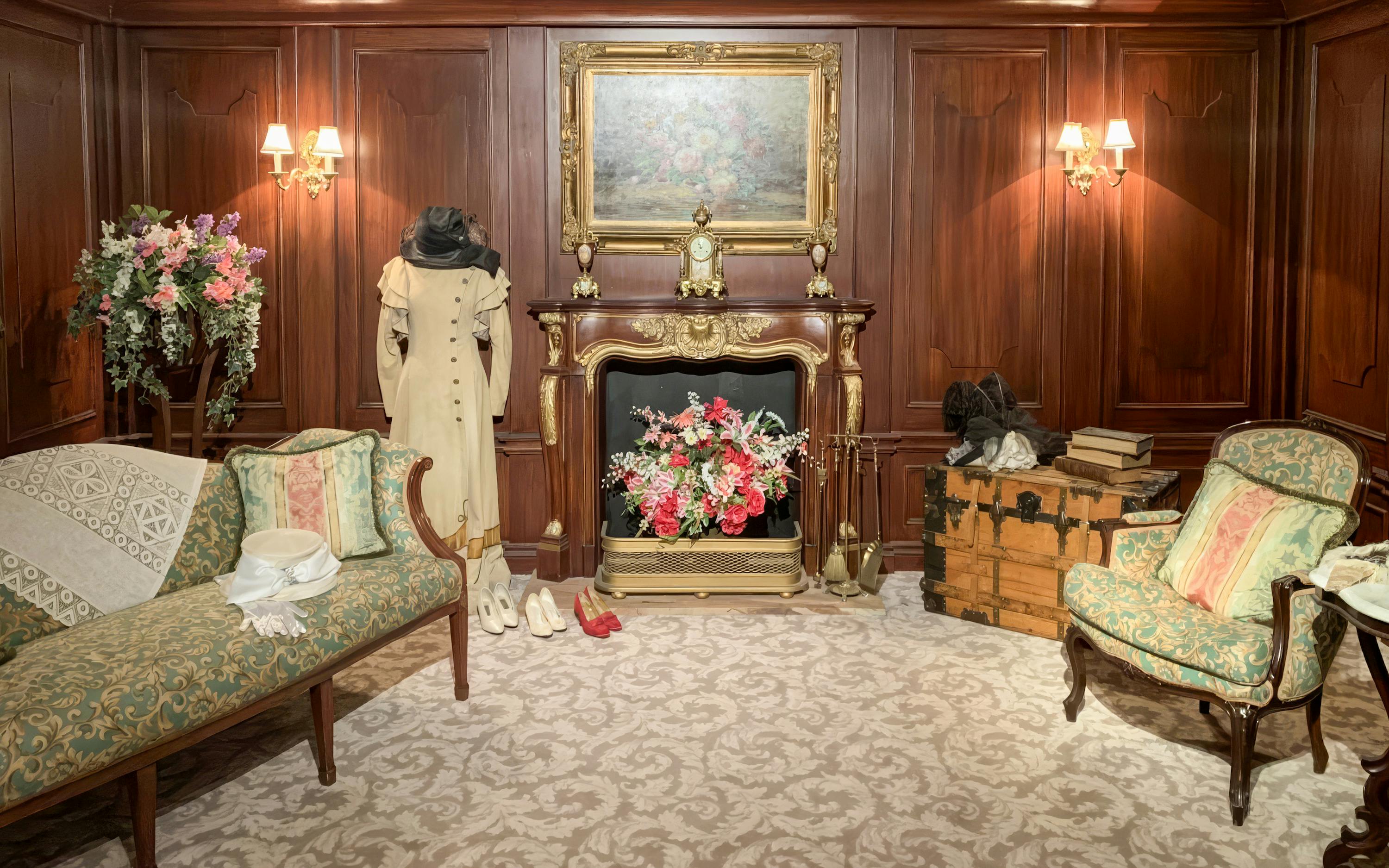 Titanic first-class cabin replica with period furniture and clothing display.