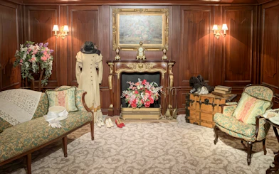 Titanic first-class cabin replica with period furniture and clothing display.