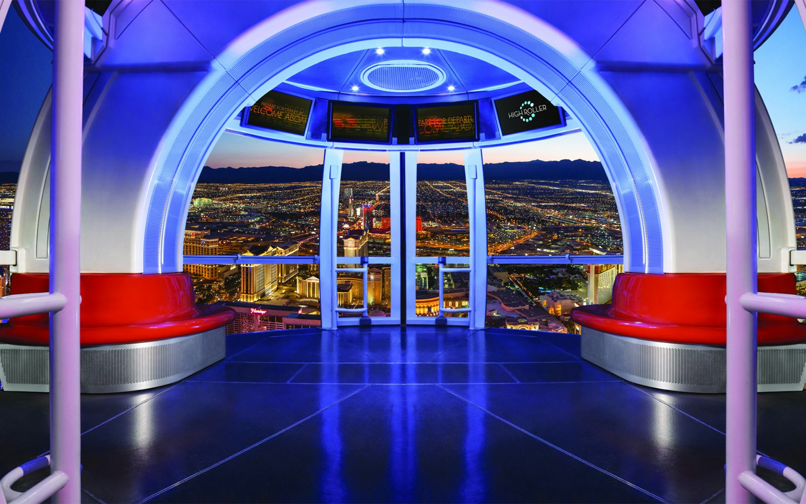 Las Vegas High Roller cabin interior with city lights view at night.