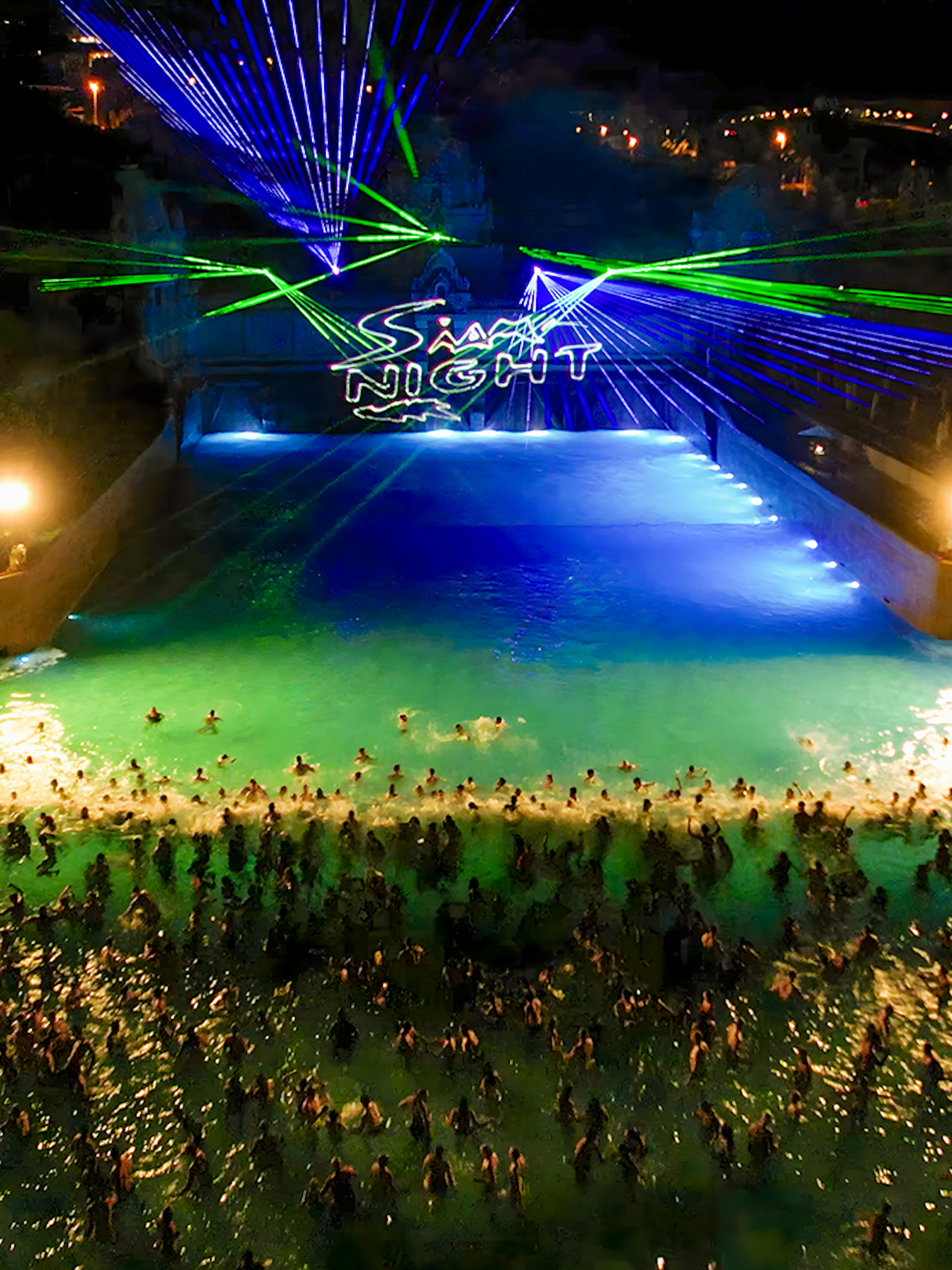 Crowd enjoying a night event with laser lights at Siam Park.