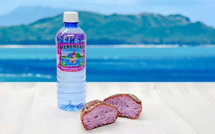Poi malasada and Hawaiian water bottle with ocean view in Hawaii.