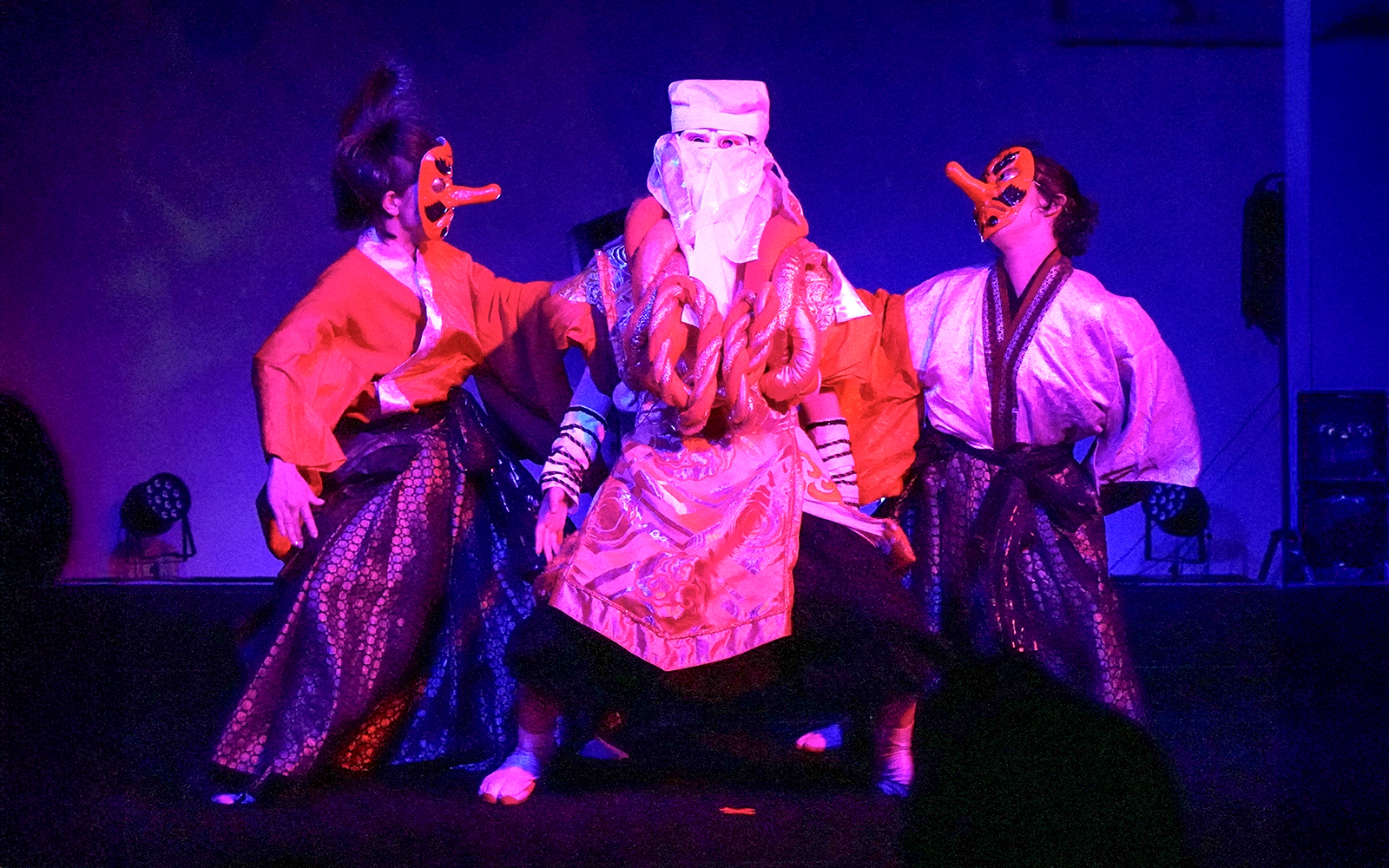 Performers in traditional costumes and masks at a Japanese festival dance show in Tokyo.