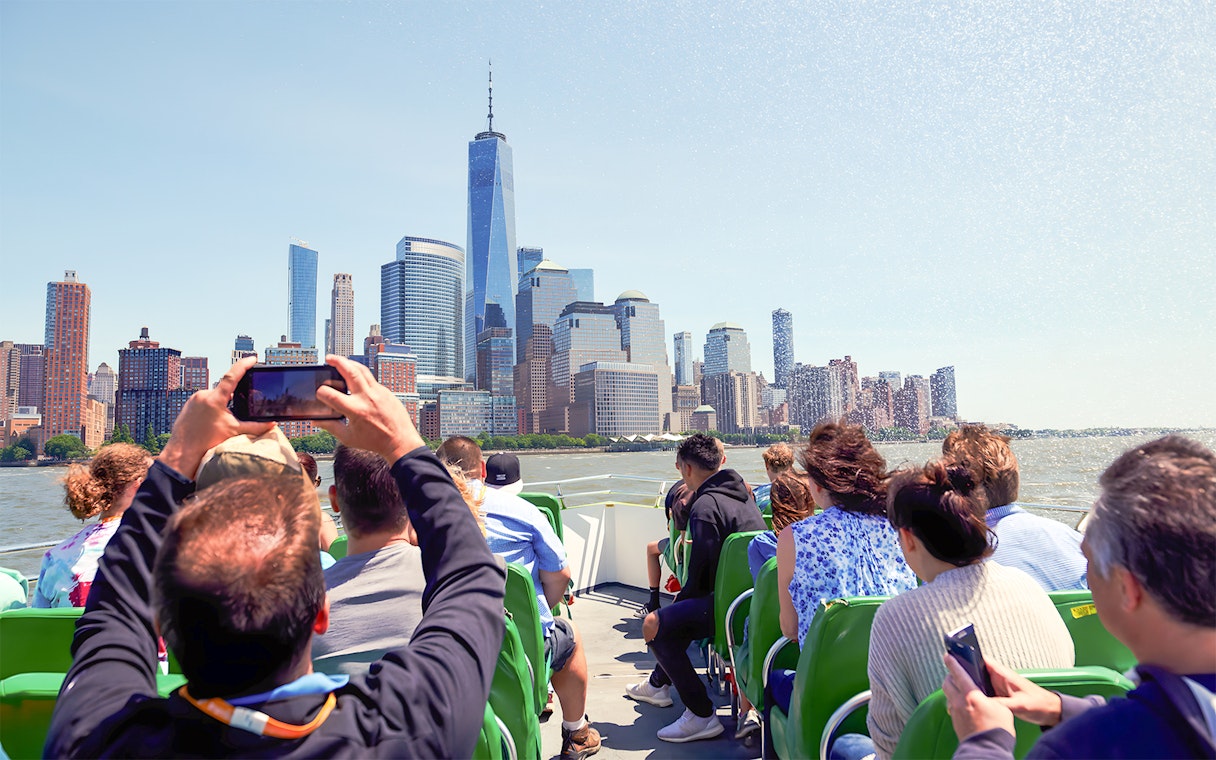 Guests on NYC speedboat ride with view of Manhattan skyline.