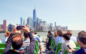 Guests on NYC speedboat ride with view of Manhattan skyline.