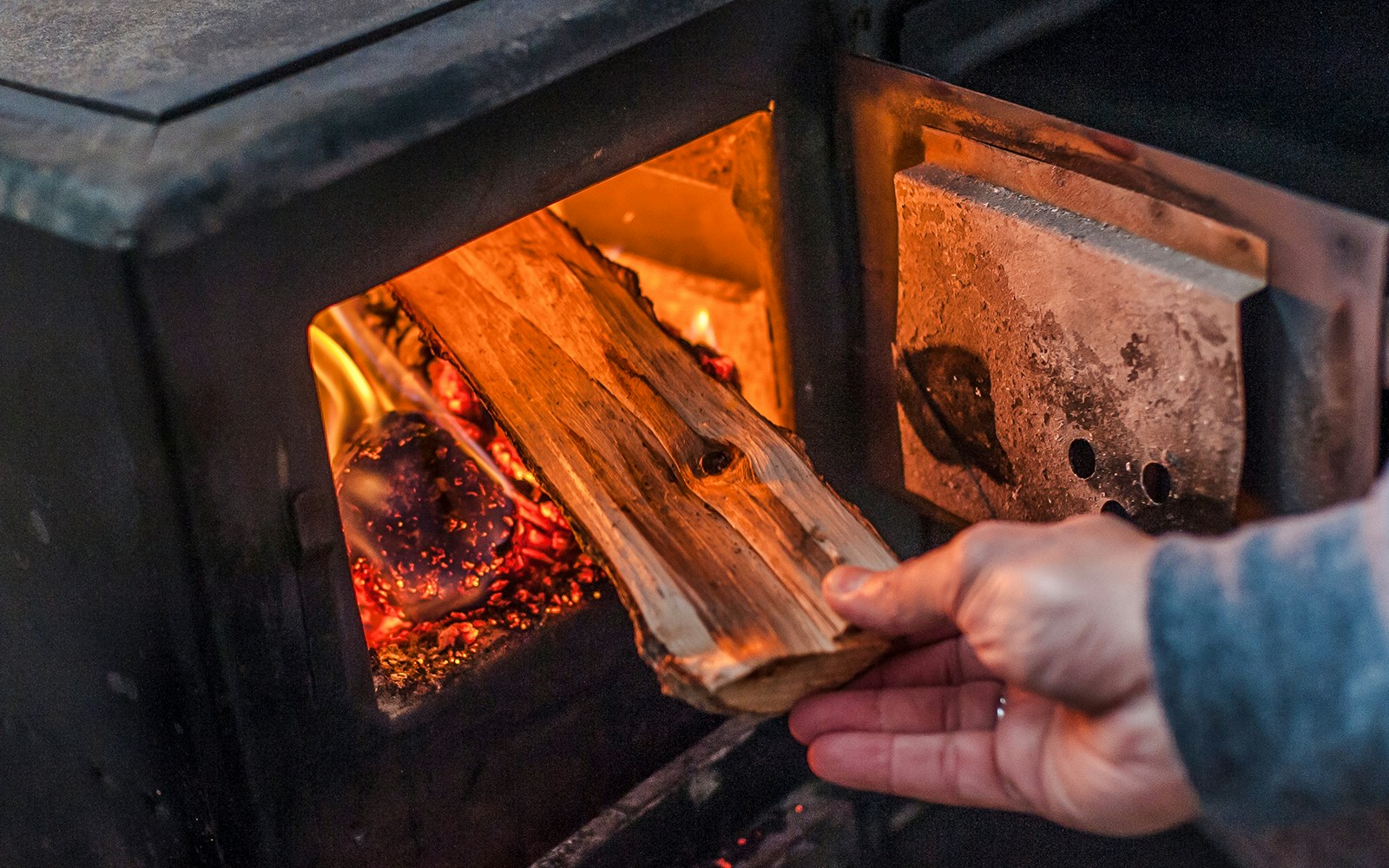 Inserting wood into a stove in Arachova Village.
