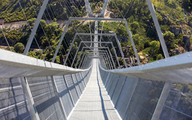 Pedestrian view of 516 Arouca suspension bridge spanning a lush valley in Portugal.