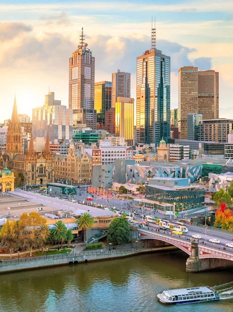 Melbourne skyline with Yarra River and city buildings at sunset.