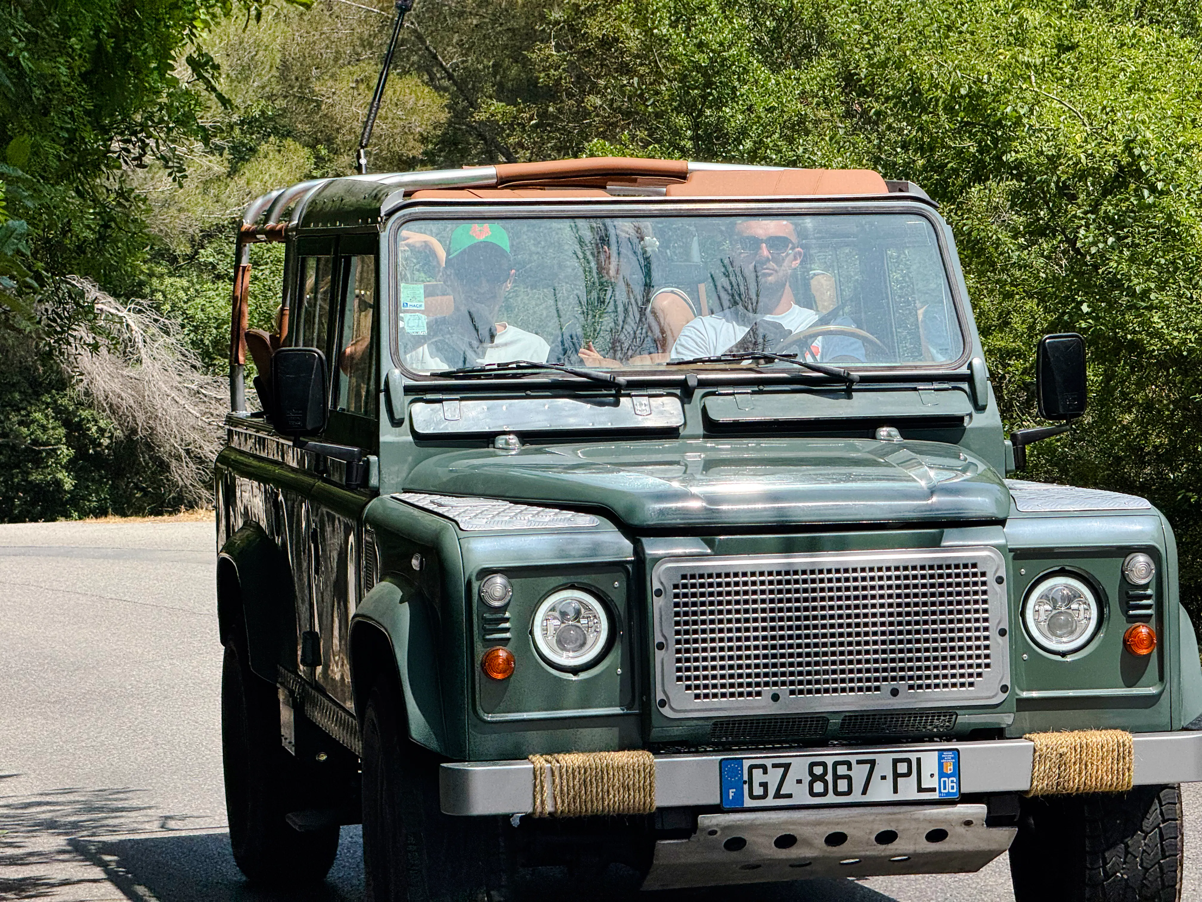 Land Rover driving through lush greenery for wine tasting tour in historic Nice château.