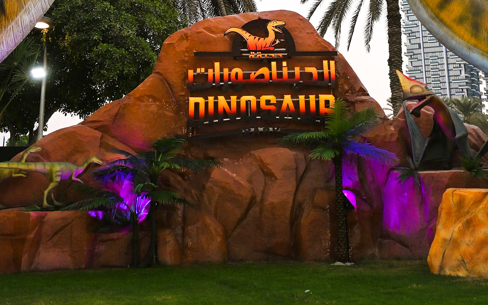 Dinosaur sculptures and sign at Dubai Garden Glow.