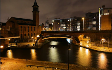 Historic canal and bridge in Manchester at night, part of the self-guided city exploration game.