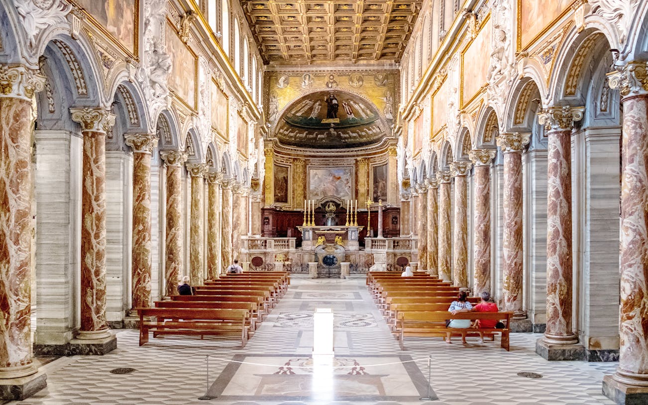 Interior of Basilica of San Marco in Rome with ornate columns and altar.