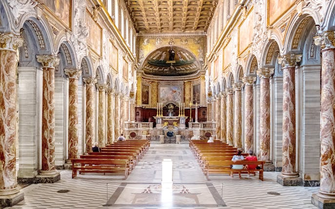 Interior of Basilica of San Marco in Rome with ornate columns and altar.