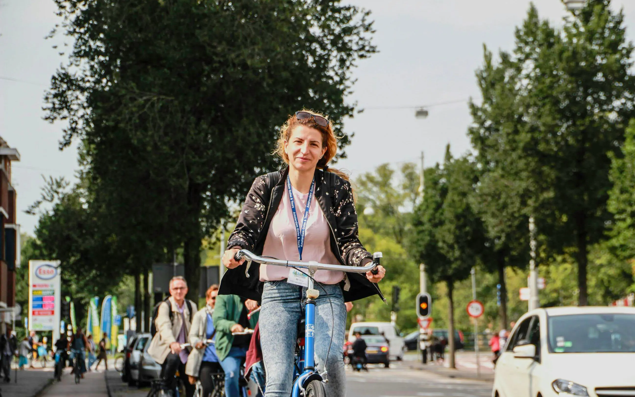 Cyclist enjoying a scenic ride on an Amsterdam street during a bike tour.