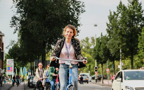 Cyclist enjoying a scenic ride on an Amsterdam street during a bike tour.