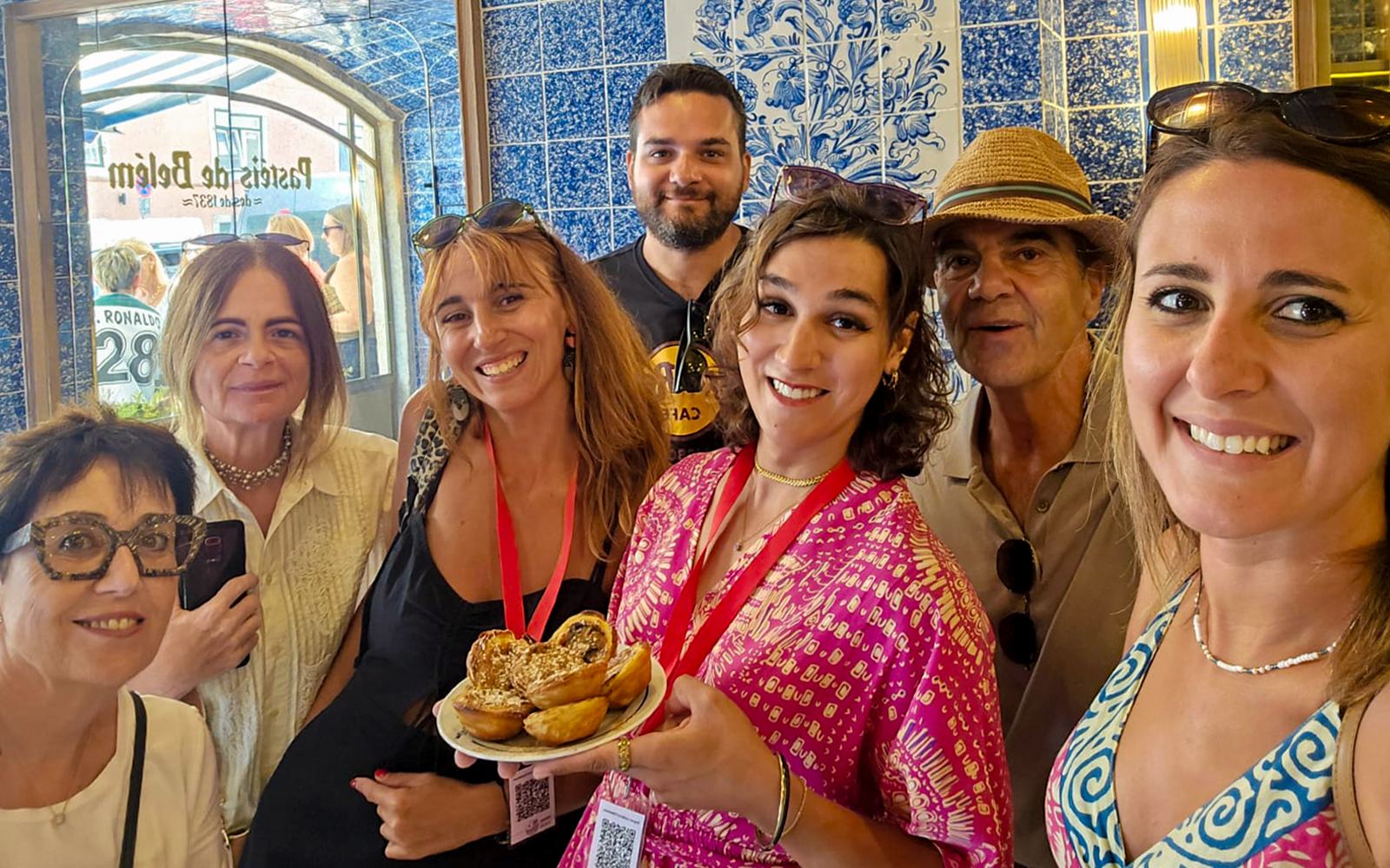 Tourists with a guide enjoying local pastries in a Lisbon bakery, Portugal.