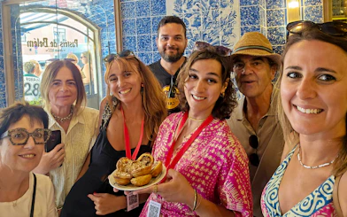 Tourists with a guide enjoying local pastries in a Lisbon bakery, Portugal.