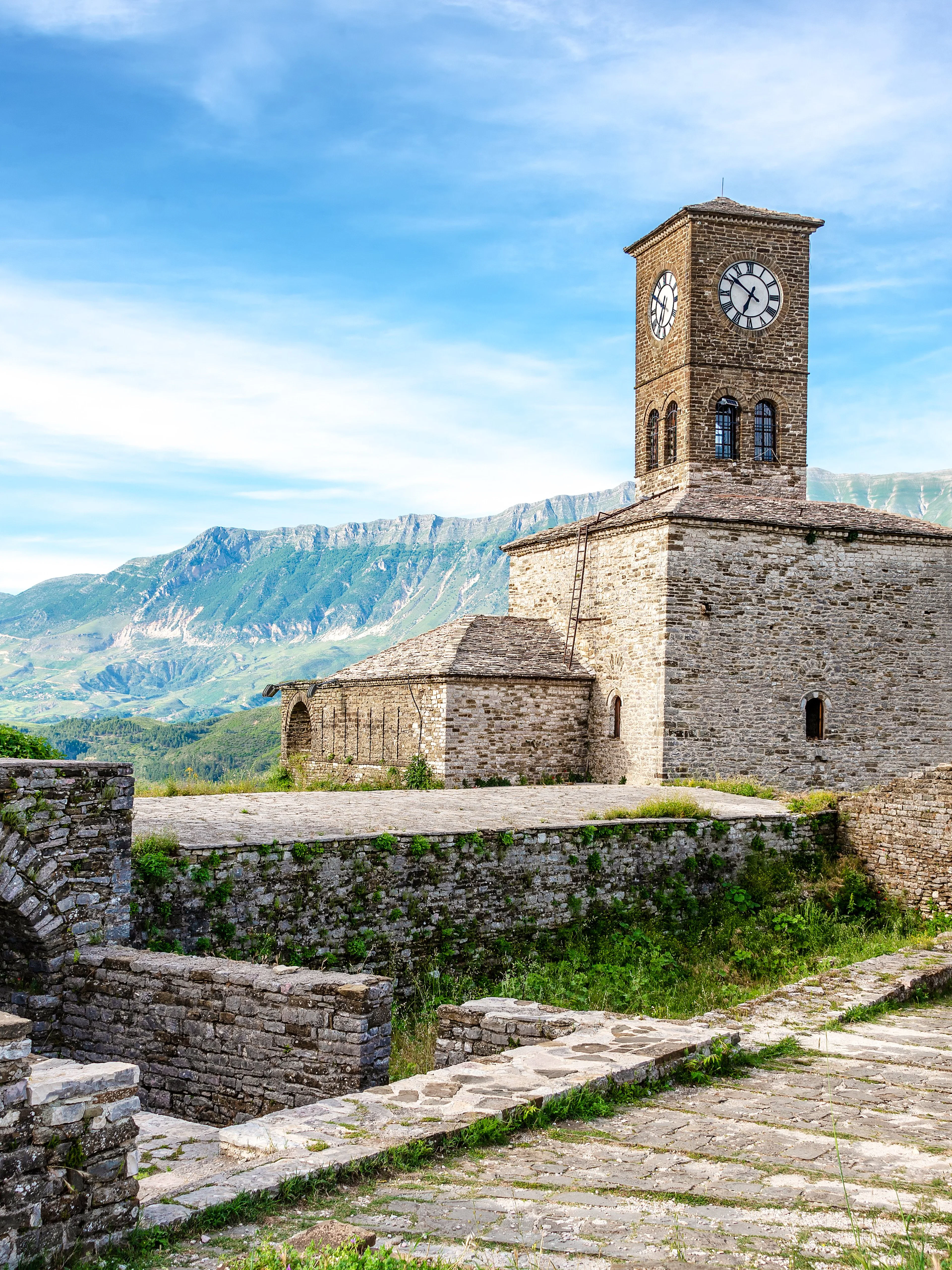 Clocktower at Gjirokaster Castle with mountain backdrop, Albania.