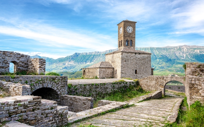 Clocktower at Gjirokaster Castle with mountain backdrop, Albania.