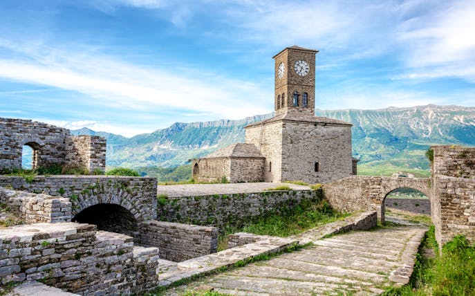 Clocktower at Gjirokaster Castle with mountain backdrop, Albania.