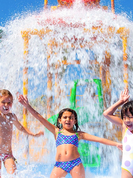 Children playing under a water fountain at Aqualand Maspalomas.