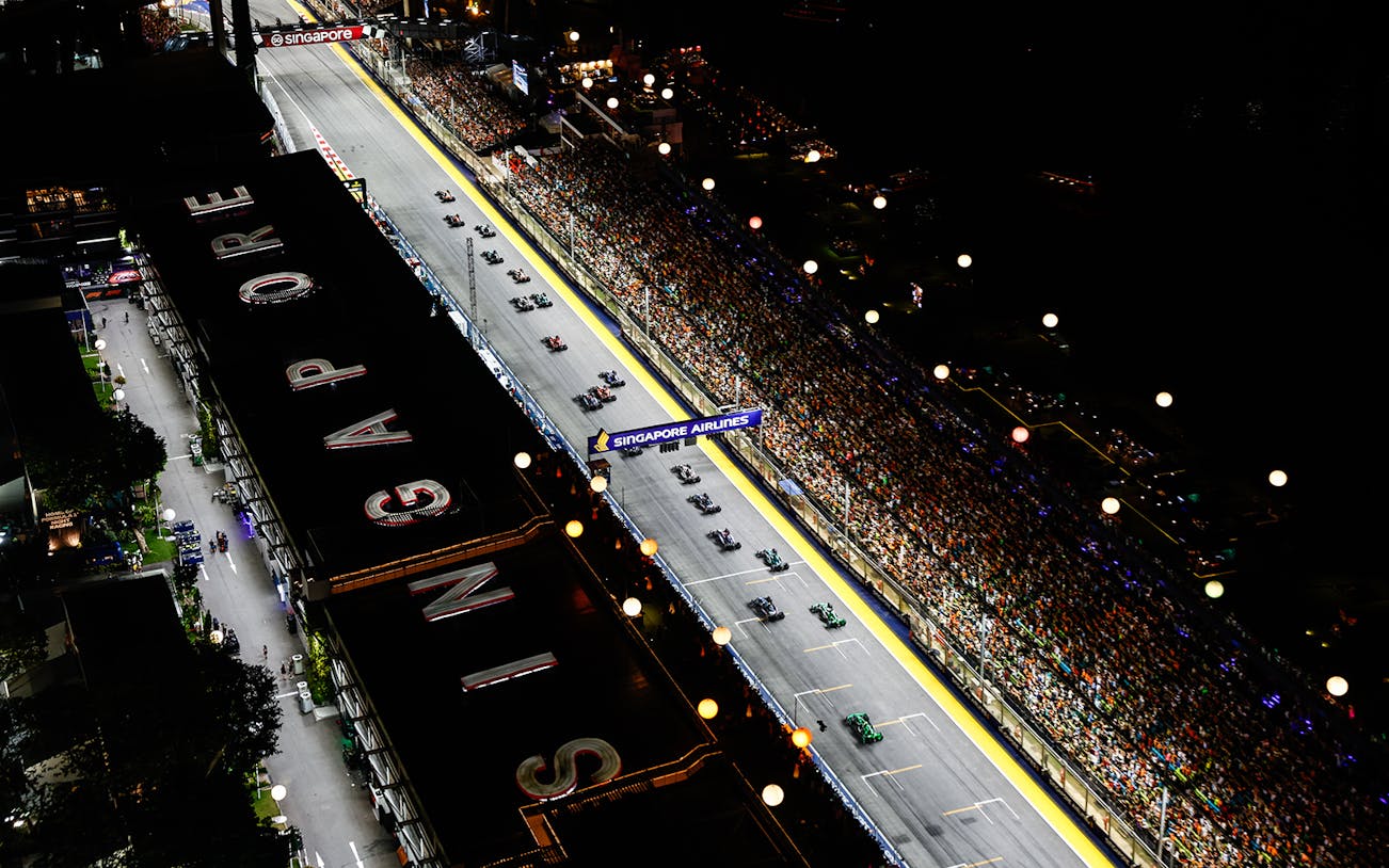 Aerial view of Formula 1 Singapore Grand Prix 2025 night race with packed grandstands.