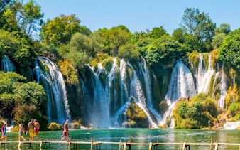 Visitors walking near Kravica waterfalls in Bosnia and Herzegovina.