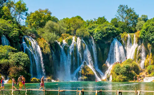 Visitors walking near Kravica waterfalls in Bosnia and Herzegovina.