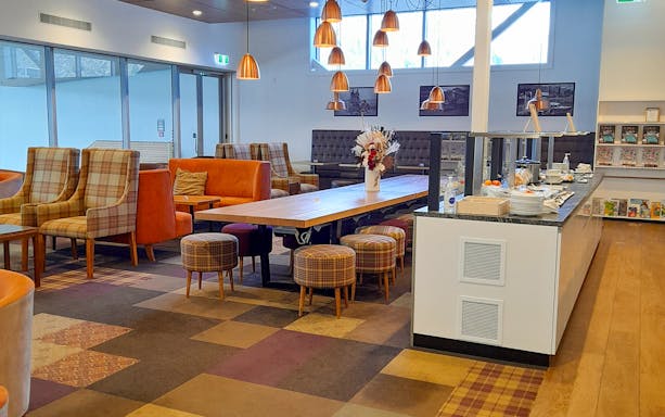 Manaia Plaza Premium Lounge seating area with buffet and modern decor.