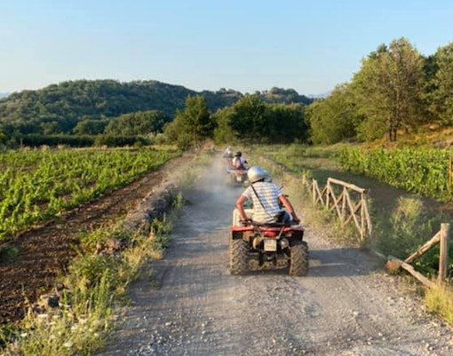 Quad bikes on rocky terrain at Alcantara Gorges, Sicily, with Mount Etna in the background.