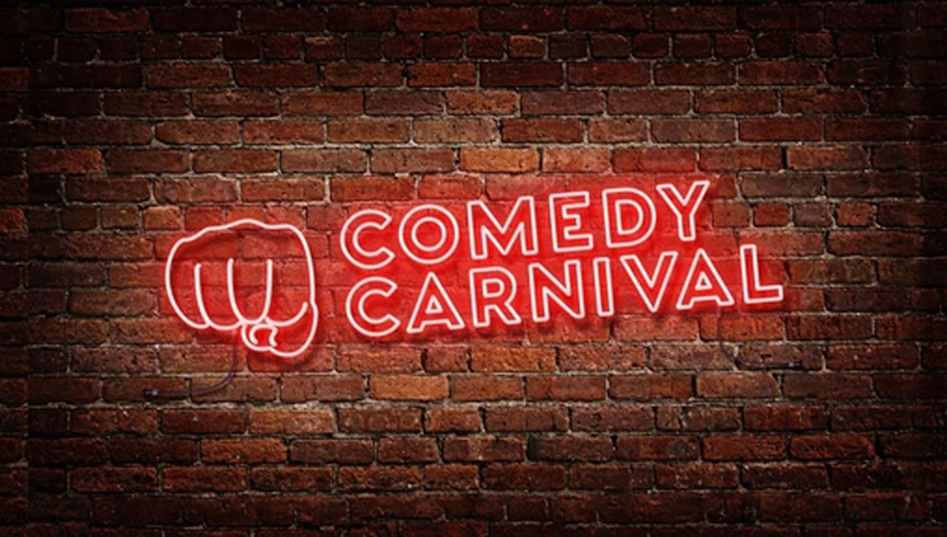 Comedy Carnival neon sign on brick wall, Covent Garden.