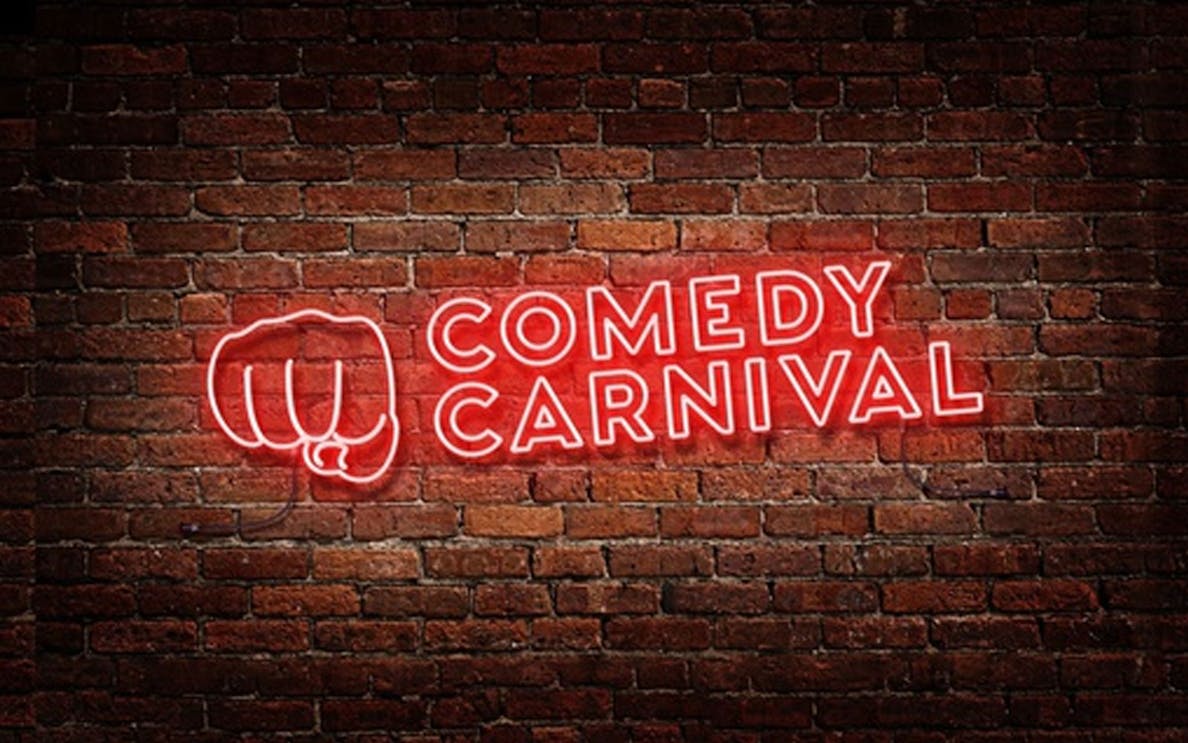 Comedy Carnival neon sign on brick wall, Covent Garden.