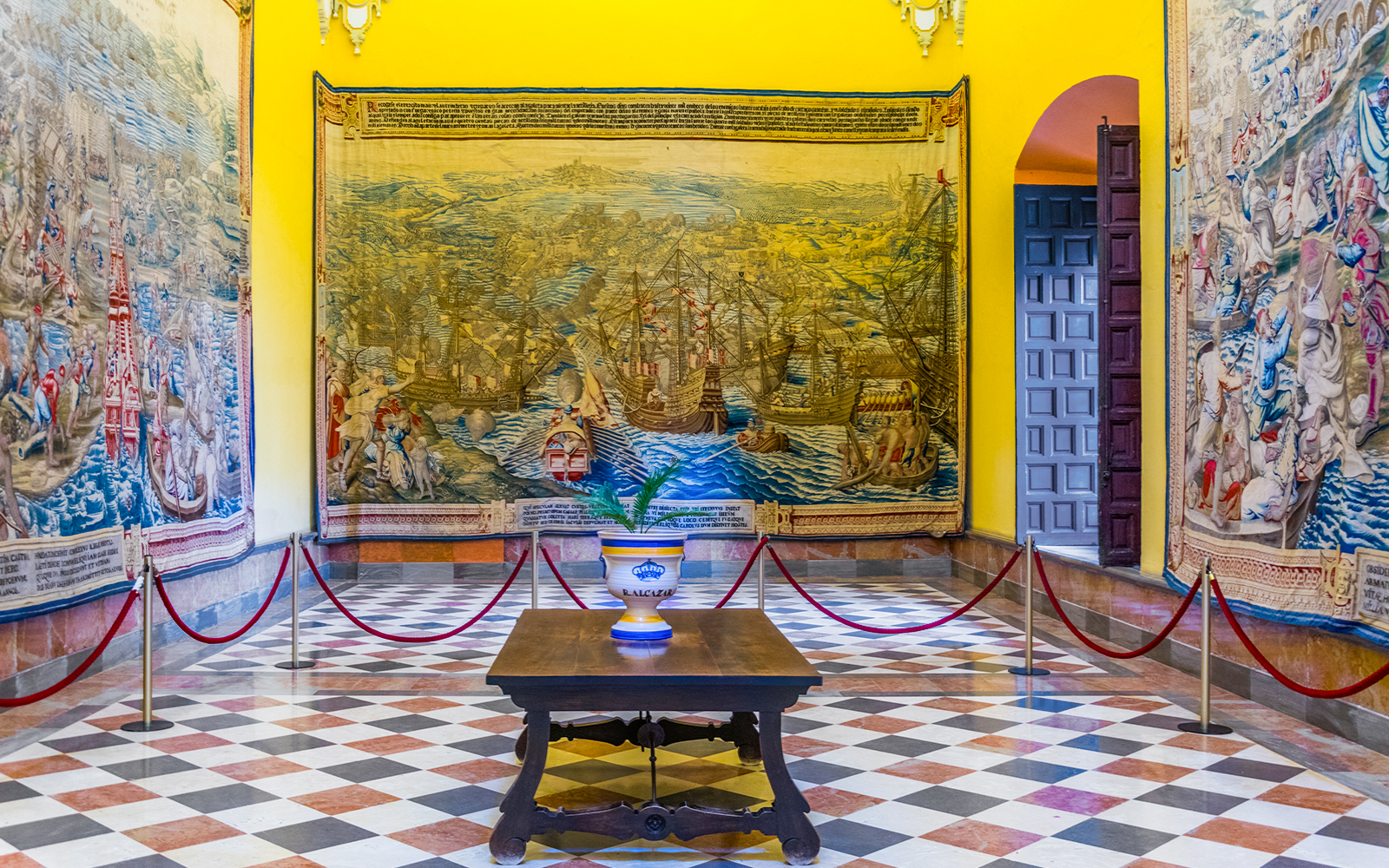 Tapestry room in the Alcazar of Seville displaying intricate maritime scenes.