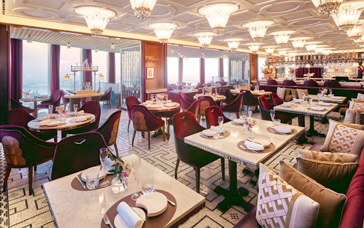 Dining area of At.Mosphere restaurant, Burj Khalifa, with elegant table settings and panoramic city views.