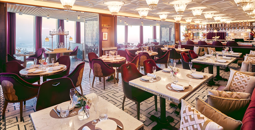 Dining area of At.Mosphere restaurant, Burj Khalifa, with elegant table settings and panoramic city views.