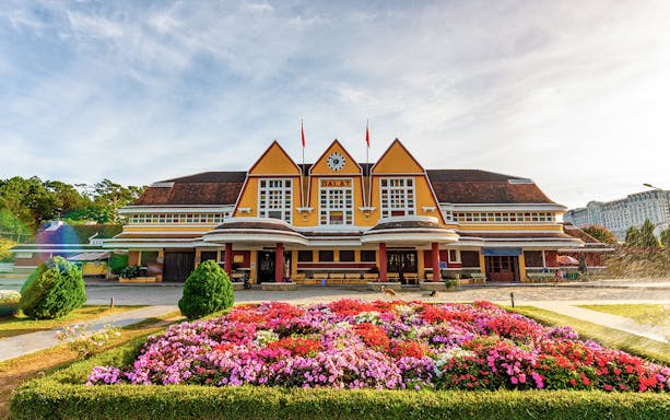 Dalat railway station with colorful flower garden in front.